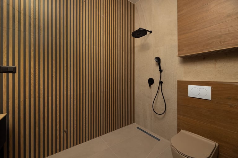 Modern bathroom interior with wood-slat shower wall, rainfall and hand shower fixtures, toilet, and beige tiled accents