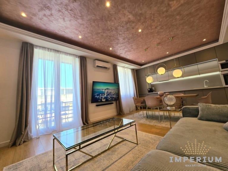 Modern luxury living room with metallic ceiling, glass coffee table, wall-mounted TV, floor-to-ceiling windows, and contemporary furnishings