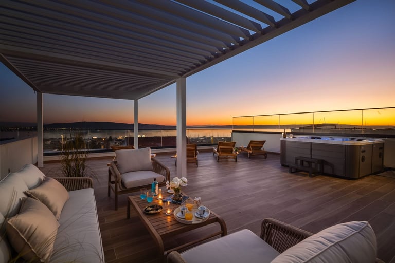 Luxury rooftop terrace with modern lounge furniture, pergola shade, hot tub, and sunset cityscape view