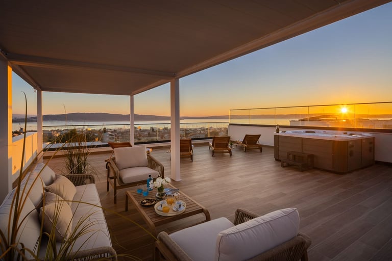 Luxury rooftop terrace at sunset with comfortable seating, lounge chairs, and an ocean view