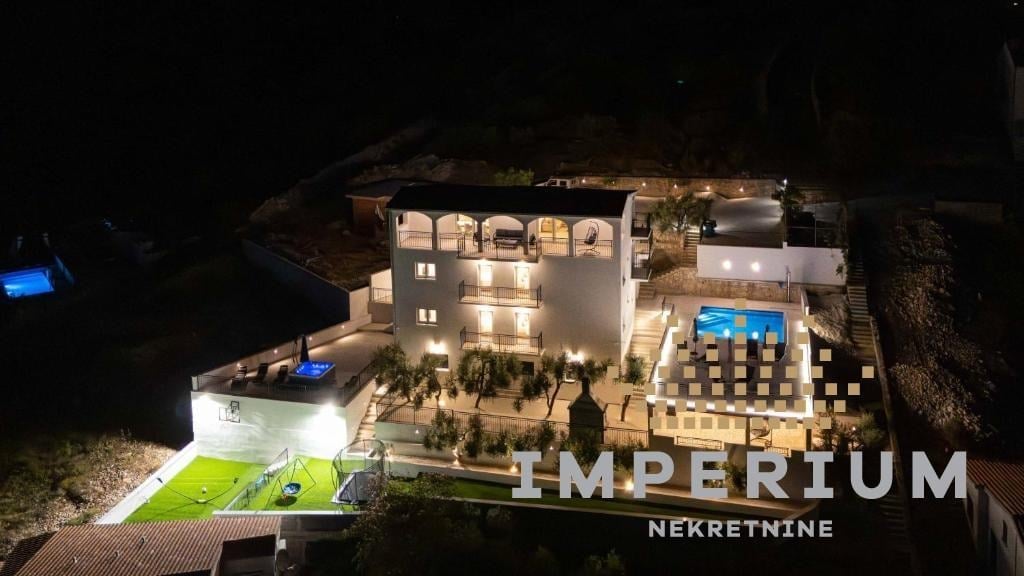 Aerial night view of Imperium Nekretnine residential complex with illuminated modern buildings and landscaped courtyard