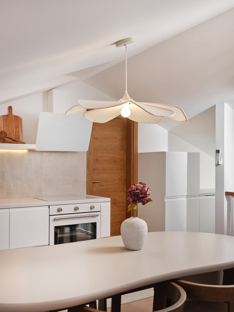 Modern pendant light with cream-colored leaf-shaped shade hanging above a white dining table in a contemporary kitchen