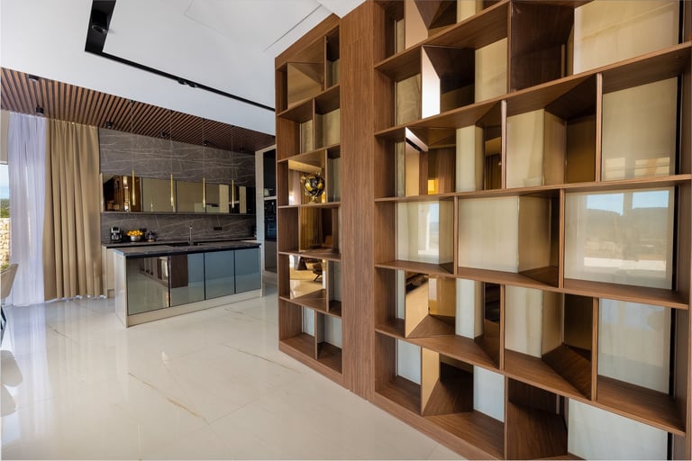 Modern kitchen and living space with wooden shelving unit, light marble flooring, and contemporary cabinetry with appliances