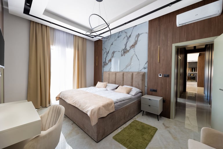 Modern luxury bedroom with gray upholstered bed, brown wood accent wall, marble headboard, and contemporary decor