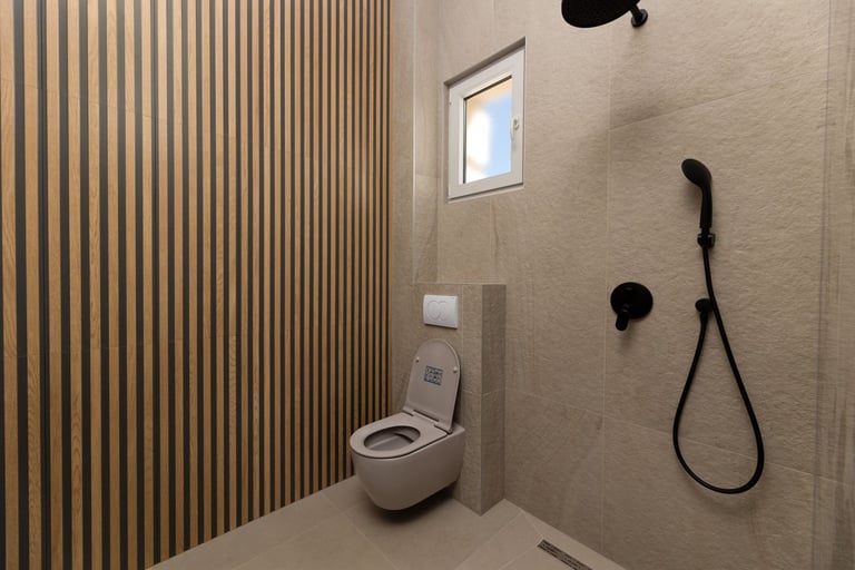 Modern minimalist bathroom with wall-mounted toilet, black shower fixtures, vertical wood-slat accent wall, and small window