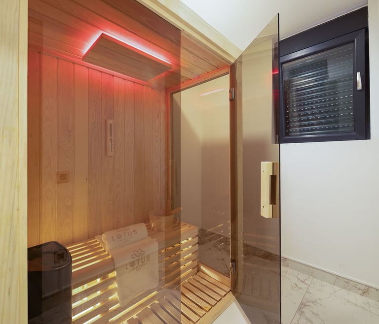 Modern infrared sauna cabin with red lighting, wooden interior, glass door, and control panel on wall