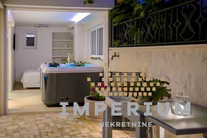 Modern spa reception area with hot tub, decorative plants, and minimalist interior design with ambient lighting