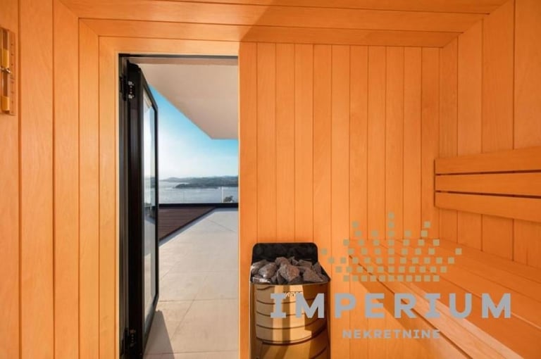 Interior of wooden sauna with open door revealing ocean and beach view beyond